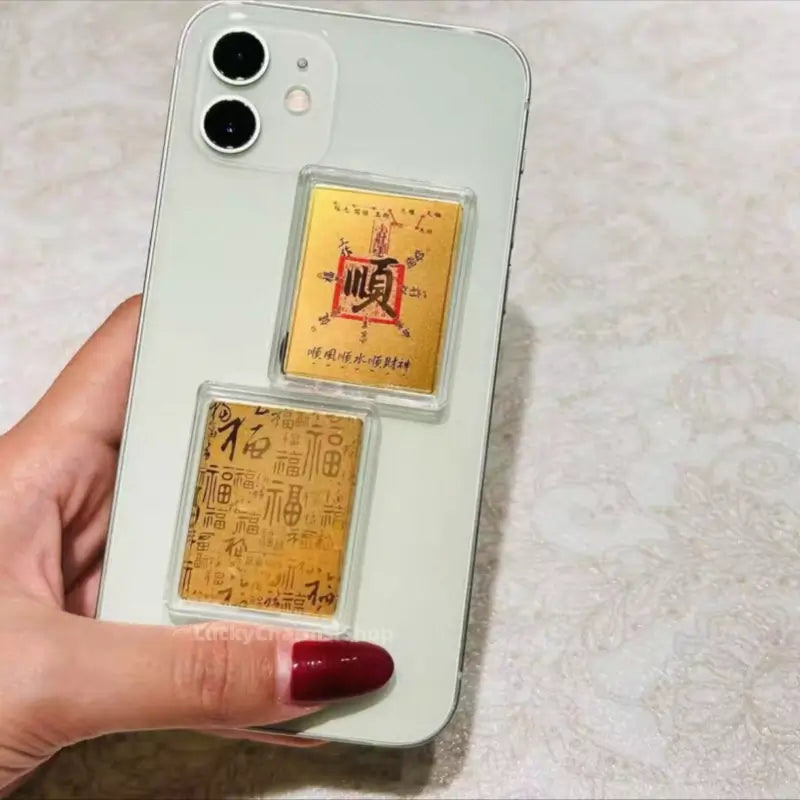 999 pure gold foil phone sticker featuring smooth fortune talisman in clear case on phone back.