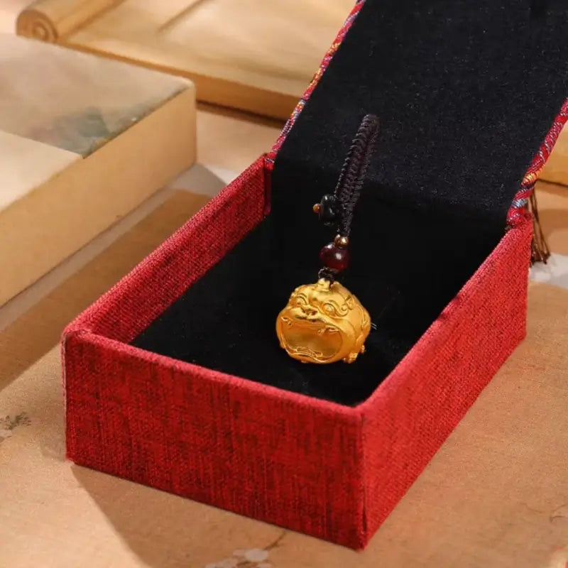 24K gold-plated Pixiu keychain pendant displayed inside a red velvet gift packaging box.