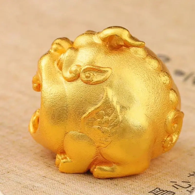 Side profile view of 24K gold-plated Pixiu bead showing carved wings and lucky motifs.