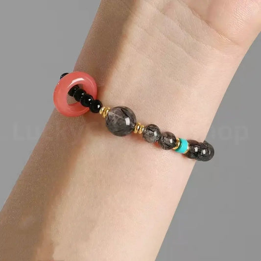 A person's wrist wearing the natural black obsidian power and protection beaded bracelet for spiritual wellness and style
