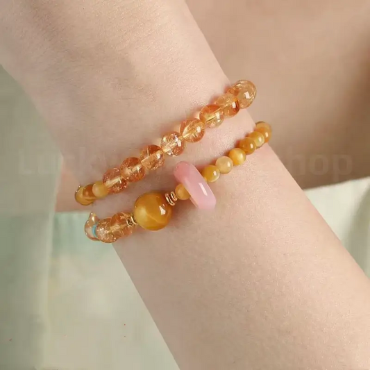 A woman wearing the vibrant yellow citrine and chalcedony double-layer abundance bracelet on her wrist