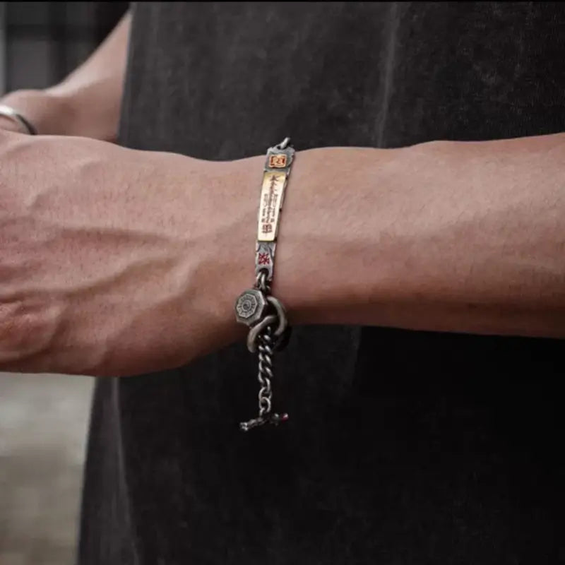 Model wearing vintage Tibetan silver God of Wealth bracelet with hanging chain and Bagua pendant.