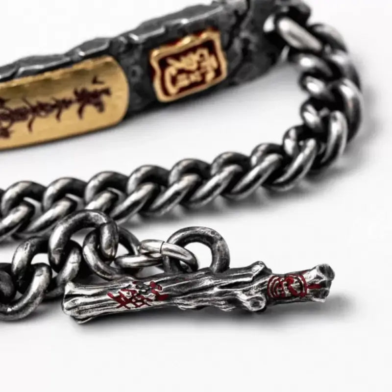 Close-up of vintage silver curb chain bracelet showcasing T-bar toggle clasp with red accents.