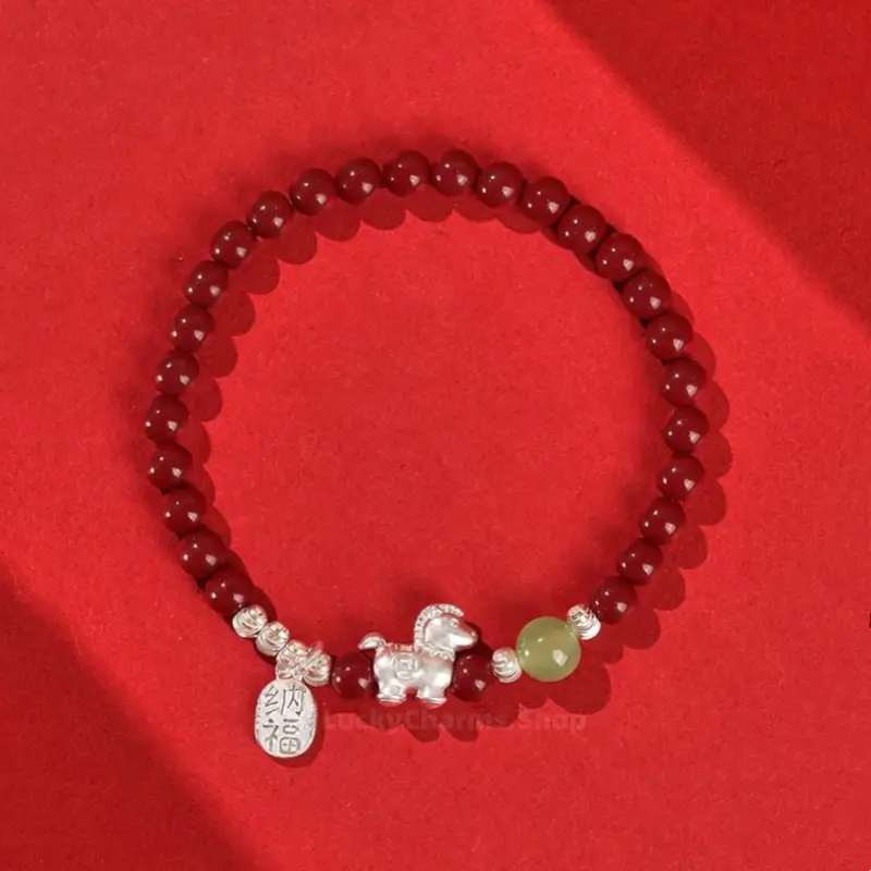 Natural red cinnabar bead bracelet featuring a 999 silver Chinese Zodiac Horse charm, jade bead, and lucky tag.