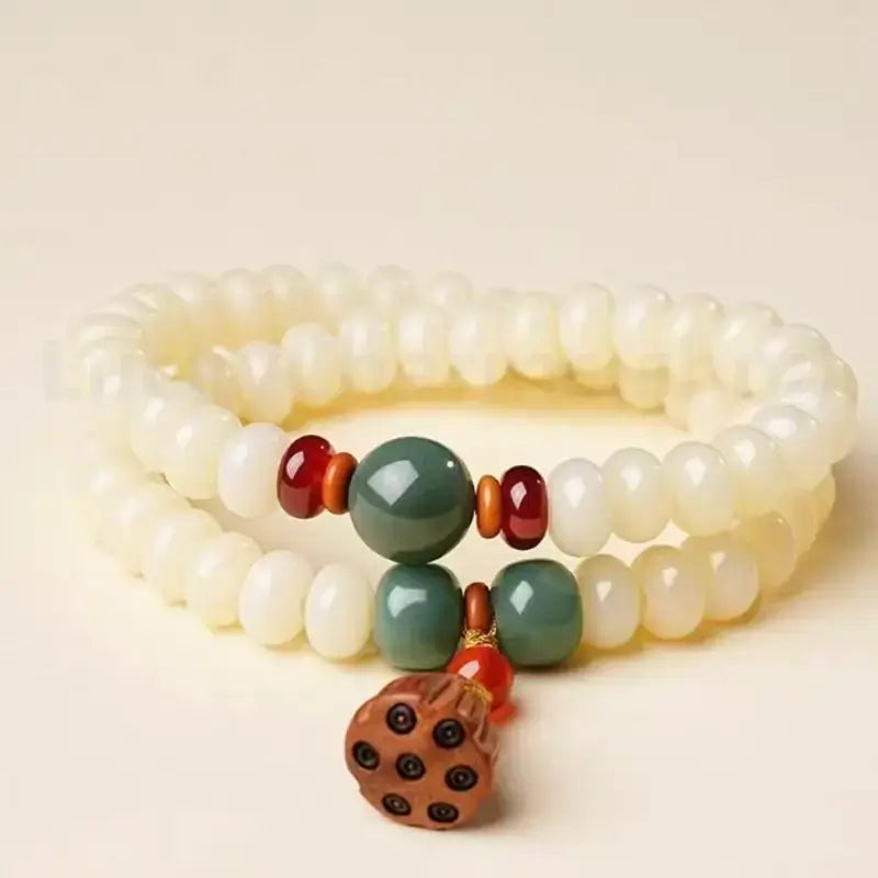 Front studio view of the double-strand white jade bodhi bead bracelet, highlighting the red carnelian and green jadeite spacer beads.