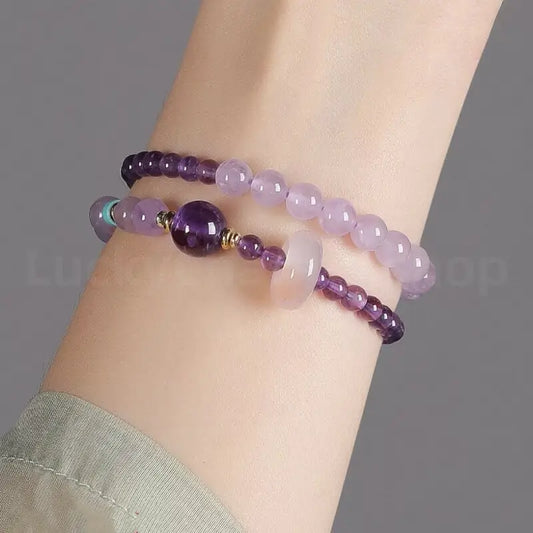 A woman's wrist wearing the natural purple amethyst double-strand healing crystal bracelet for a minimalist elegant look