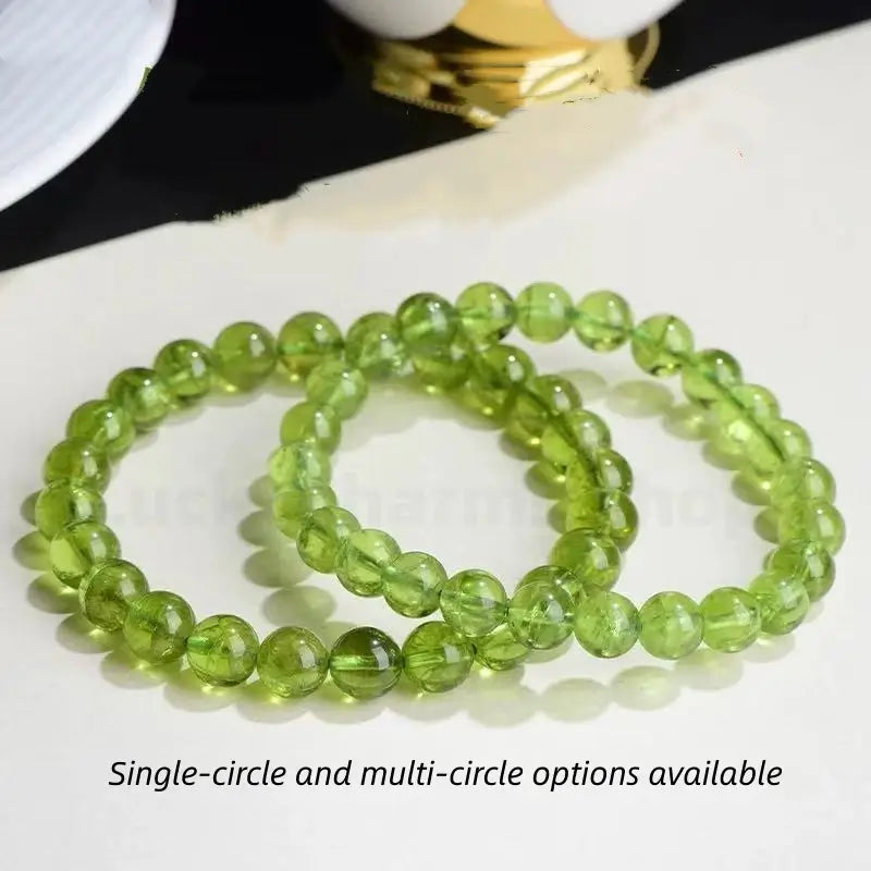 Two single-circle natural peridot beaded bracelets displayed together, featuring polished translucent olive green crystal beads.