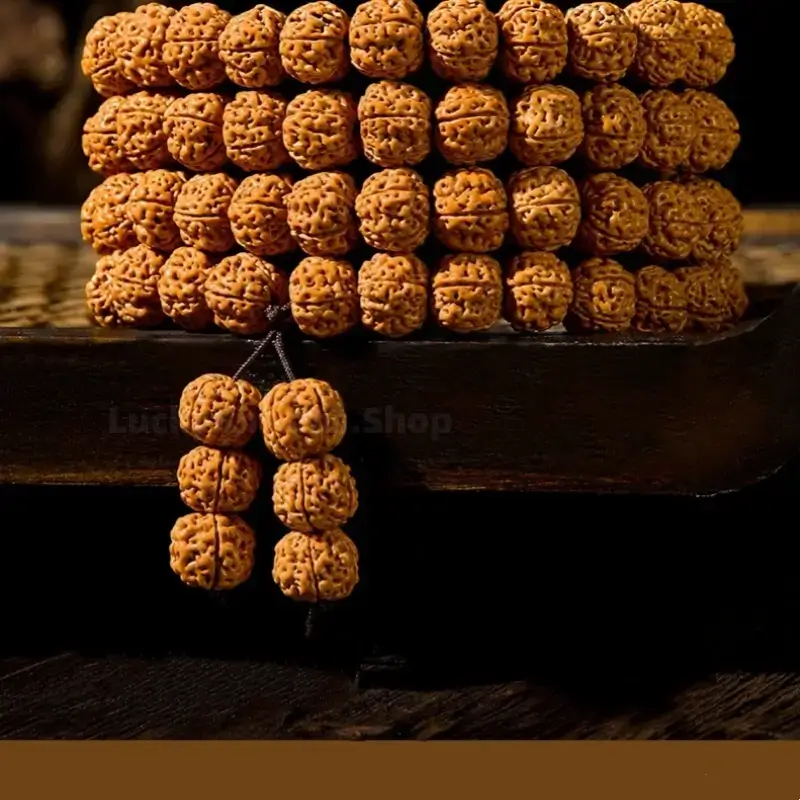 Stacked Nepalese Rudraksha 108 bead mala bracelet resting on a dark wooden surface.