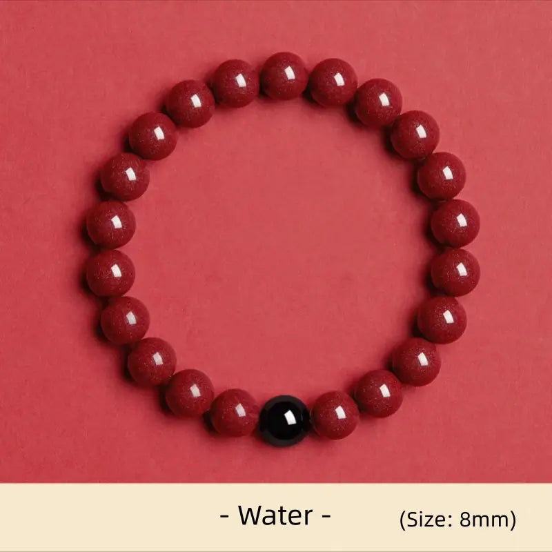 8mm natural cinnabar Water element energy bracelet featuring a black obsidian accent bead on red background.