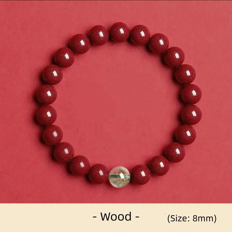 8mm natural cinnabar Wood element energy bracelet featuring a green phantom quartz accent bead on red background.