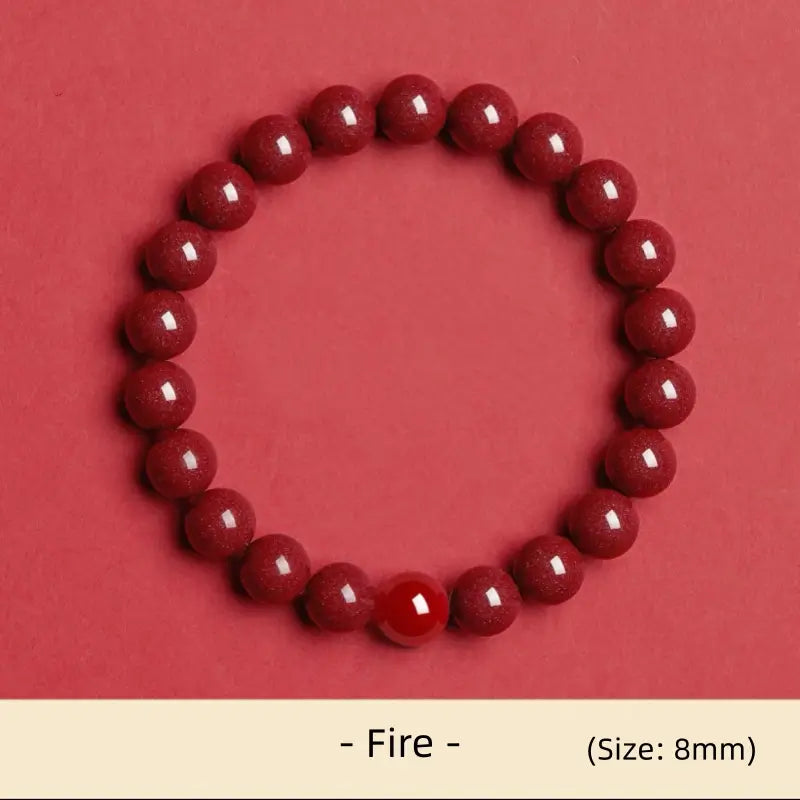 8mm natural cinnabar Fire element energy bracelet featuring a red agate accent bead on red background.