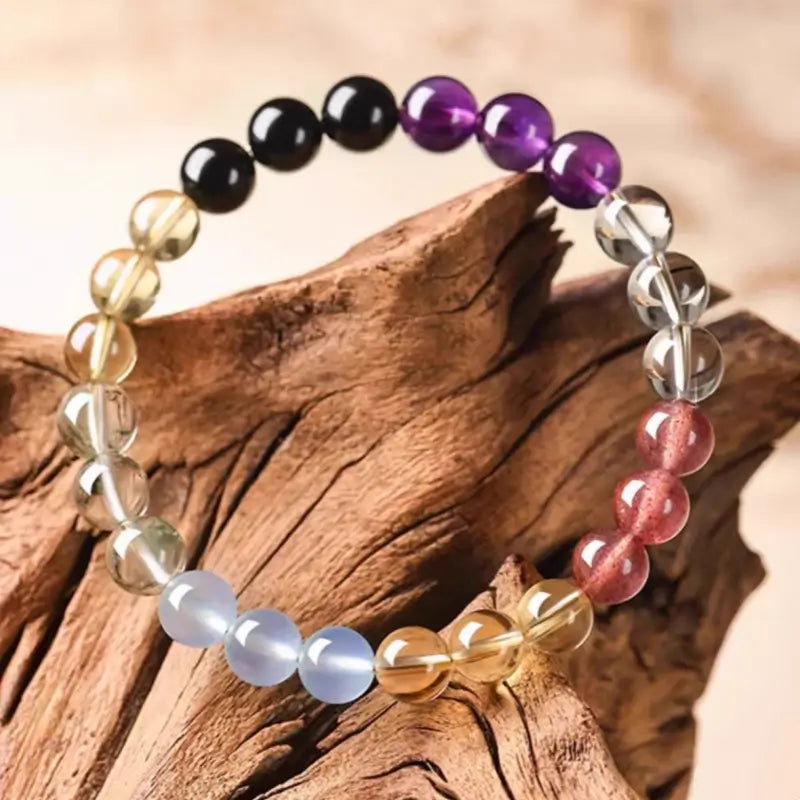 Natural multi-gemstone healing bracelet with strawberry quartz, amethyst, and aquamarine 6mm beads on wood.