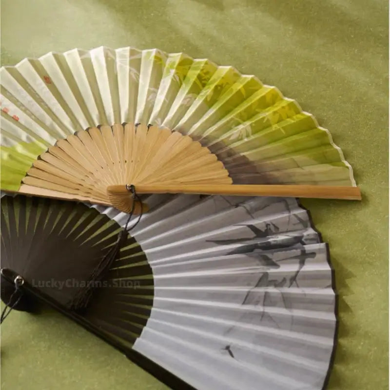 Close-up view of Nanjing Museum Chinese folding fans with natural bamboo ribs and silk calligraphy leaf.