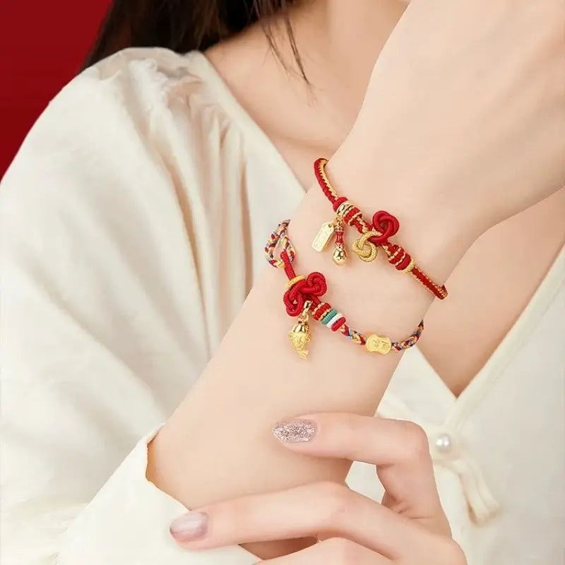 Woman wearing both hand-woven Academic Success lucky bracelets with 18K gold charms on her wrist.