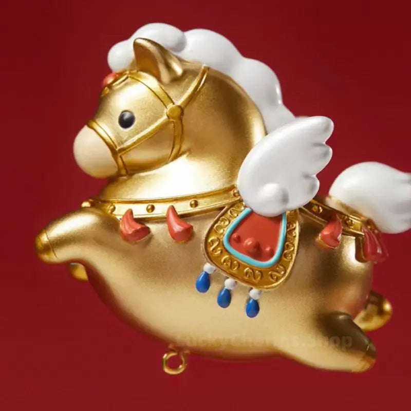 Side profile of golden winged horse fridge magnet with white wings and colorful saddle embellishments.