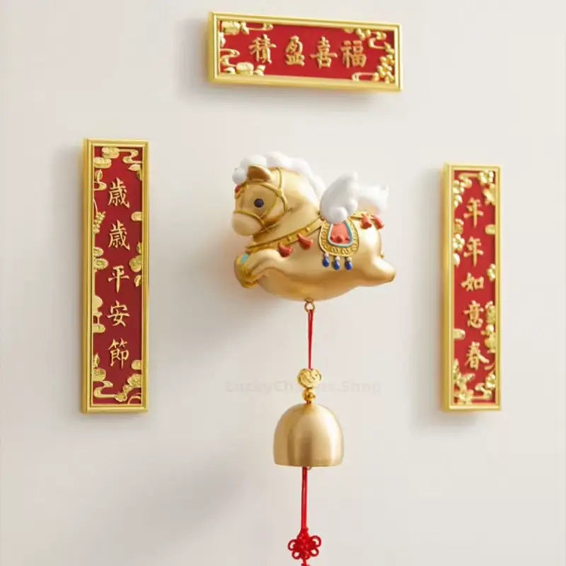 Palace Museum golden horse bell fridge magnet displayed on wall surrounded by red Chinese couplets.