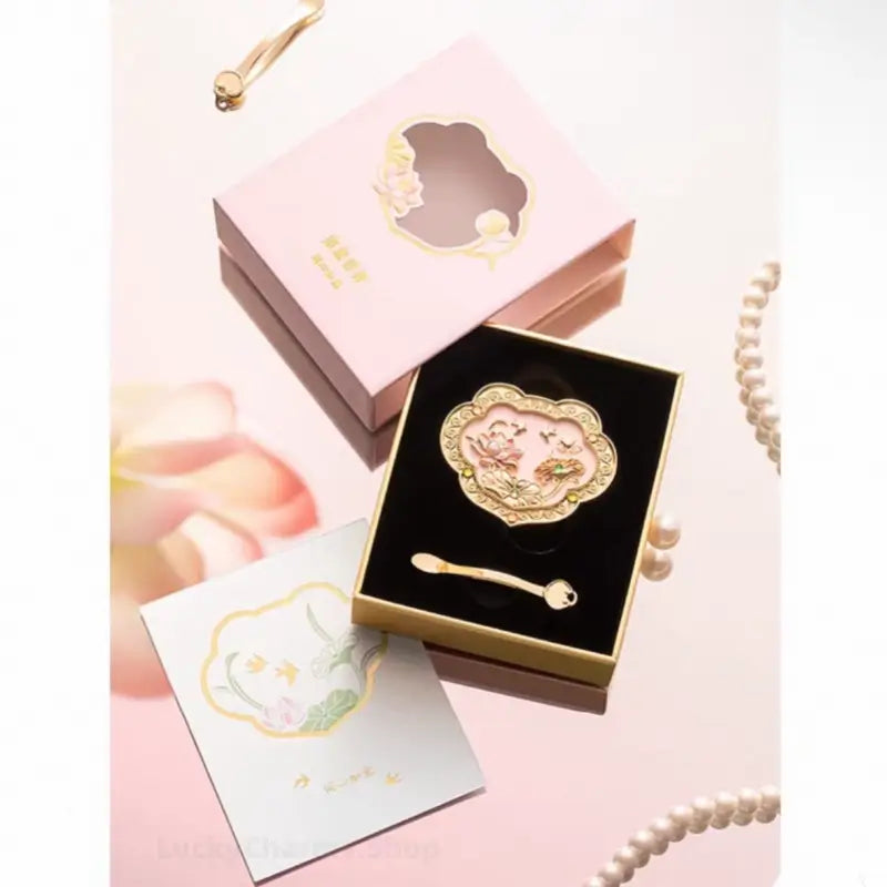 Unboxing set of pink lotus Ruyi solid perfume compact inside black velvet gift box with scoop spoon.