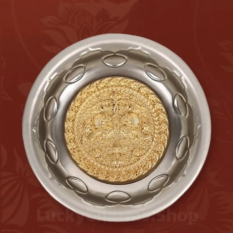 Front view of silver bowl fridge magnet featuring gilded center disc with double lion motifs.