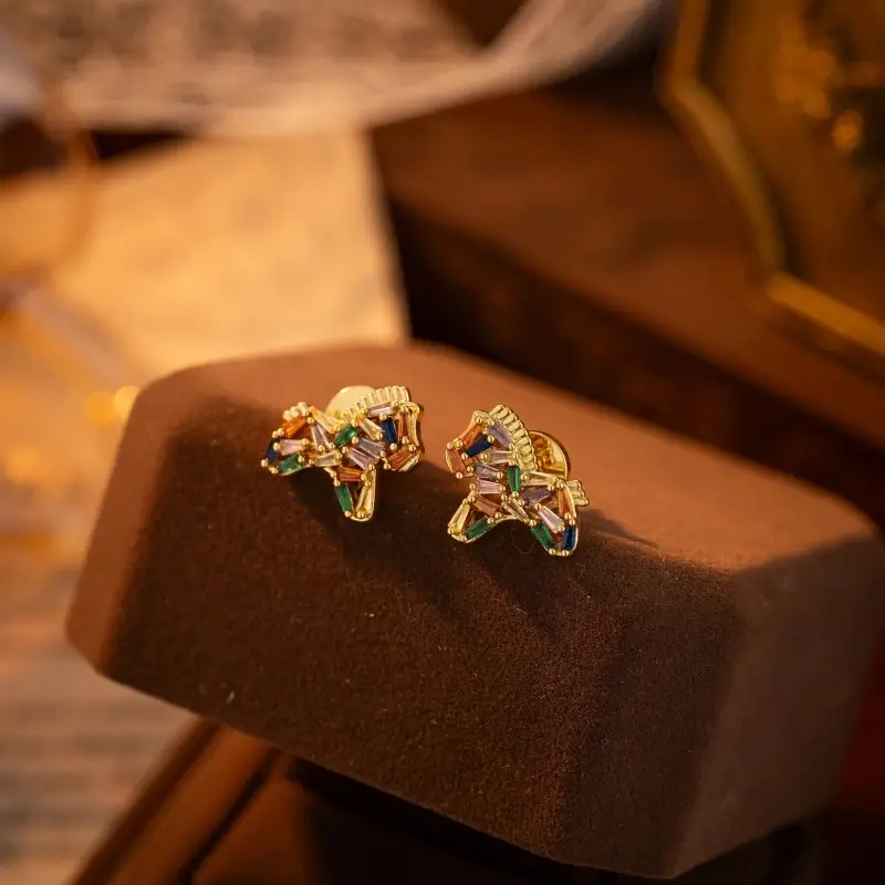 Pair of gold horse pony stud earrings embellished with colorful baguette-cut zircon gemstones.