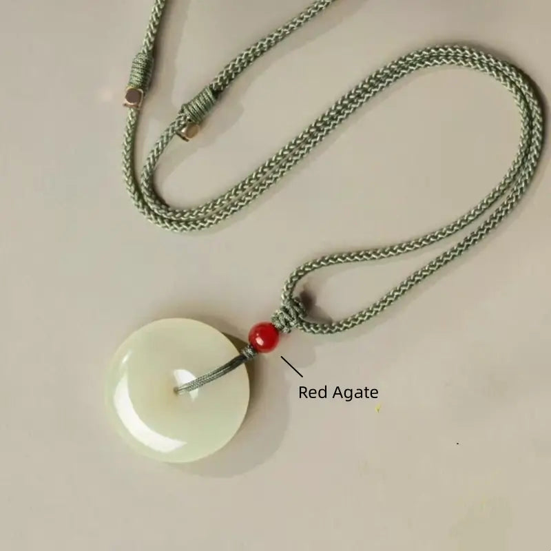 Natural Hetian jade peace buckle necklace layout with green cord and red agate bead callout.