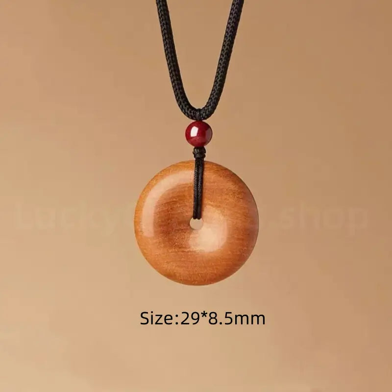 Large size peach wood peace buckle pendant necklace measuring 29 by 8.5 millimeter.