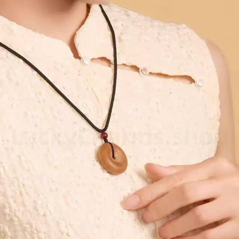Side view model shot of peach wood safety buckle necklace worn around neck