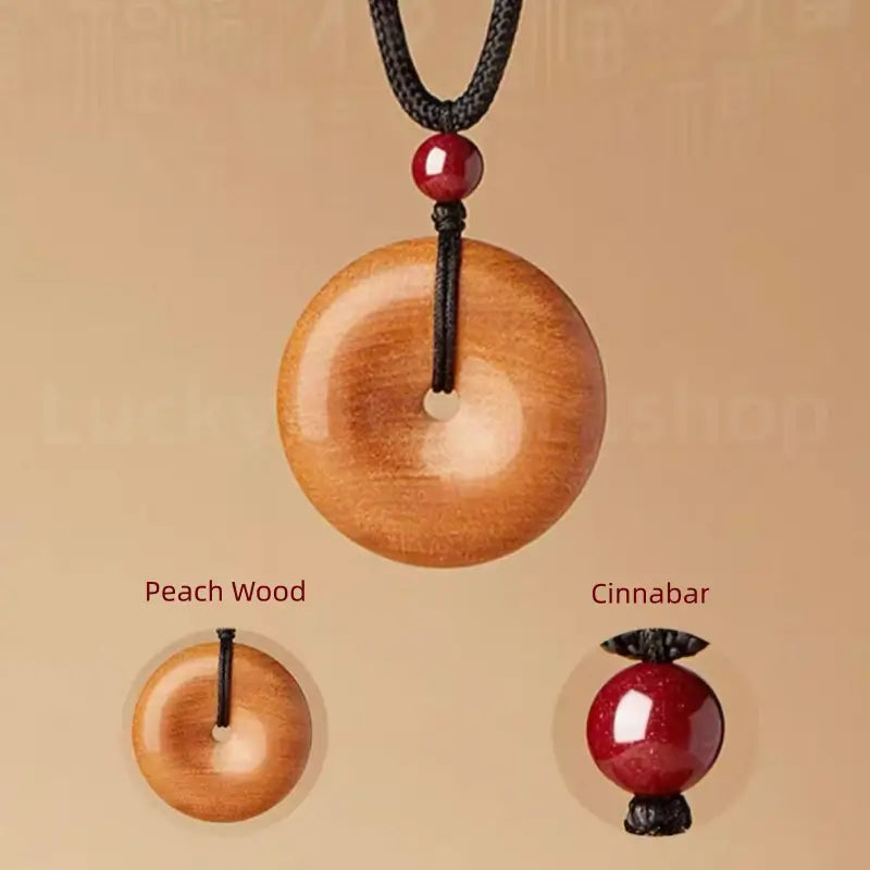 Material detail showing genuine peach wood peace buckle and glossy red cinnabar bead.