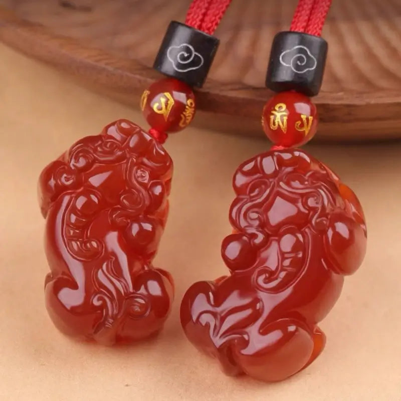 Pair of natural red agate Pixiu pendants with golden Six-Word Mantra beads and red braided cord.
