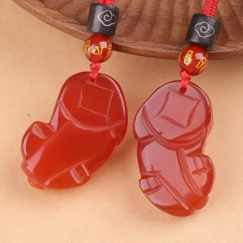 Smooth polished underside of translucent red agate Pixiu wealth amulets.