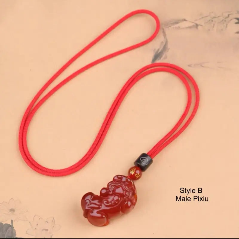 Style B Male Pixiu red agate amulet necklace with red braided cord and black cloud bead.