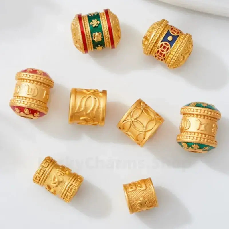 Collection of gold-plated enamel barrel spacer beads with lotus and lucky patterns for DIY jewelry.