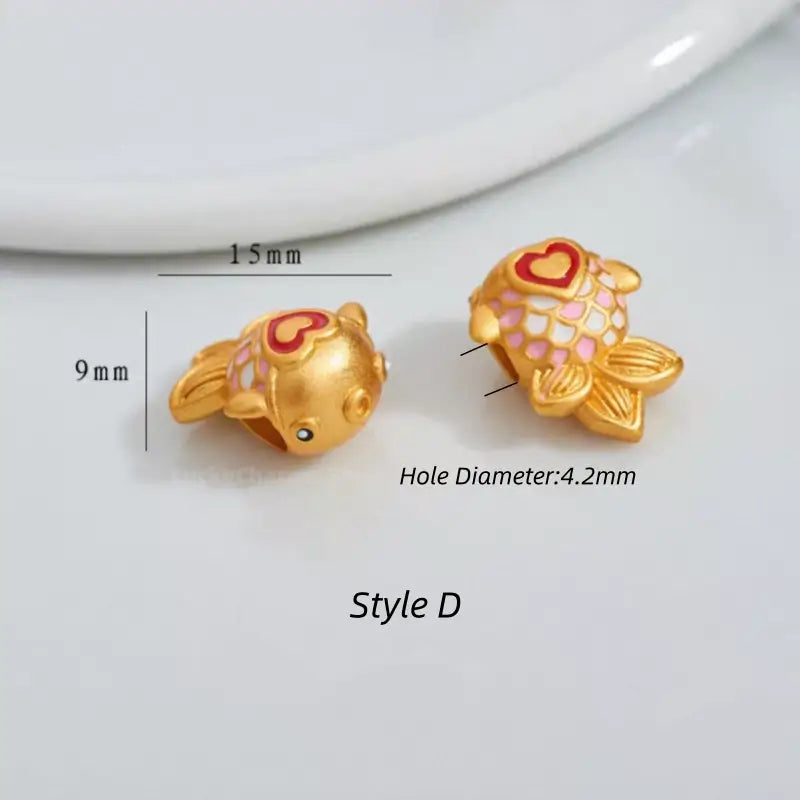 Gold fish bead featuring pink enamel scales and red heart accent, 15mm x 9mm (Style D).
