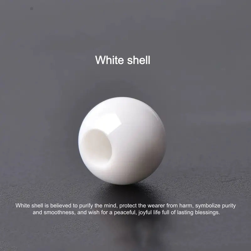 Natural white shell single large-hole round bead isolated on dark background.