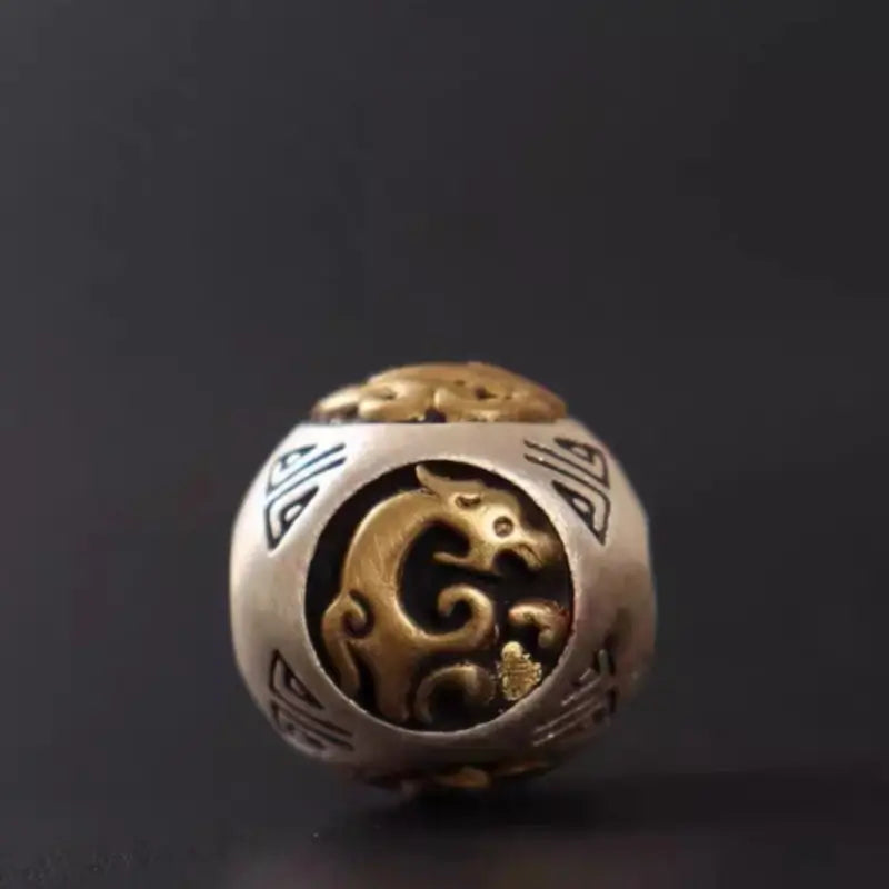 Close-up of 925 silver bead featuring brass Azure Dragon guardian beast relief inlay.