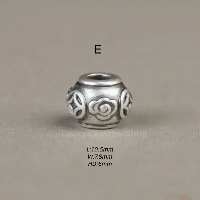 Style E 999 silver round barrel charm bead engraved with Chinese coins and cloud motifs.