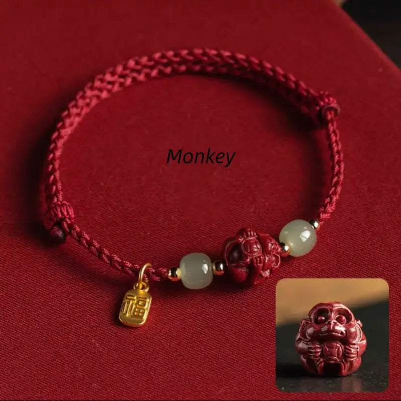 Chinese red cord lucky bracelet with detailed Monkey zodiac carved cinnabar bead and Hetian jade.