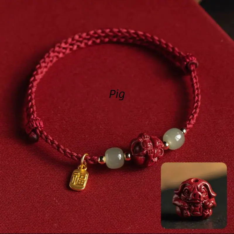 Red braided lucky charm bracelet with hand-carved Pig zodiac cinnabar bead and Hetian jade accents.