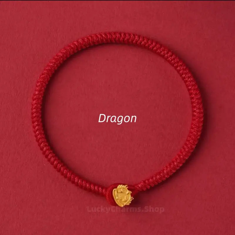 Red braided string lucky bracelet with a gold Dragon Chinese zodiac clasp against a red background.