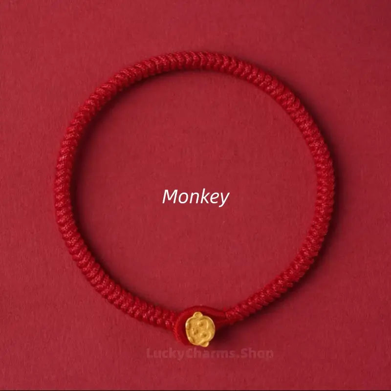 Handwoven red string lucky bracelet featuring a gold Monkey Chinese zodiac animal clasp on a red background.