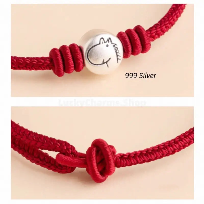 Close-up of 999 fine silver zodiac charm bead and adjustable knotted clasp on a braided red string bracelet.