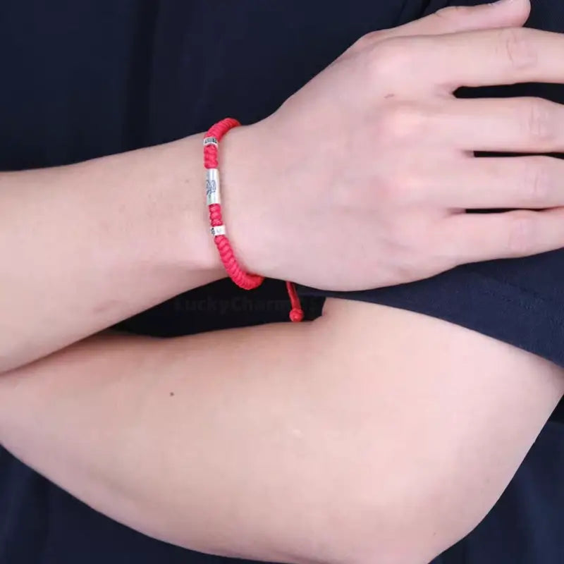 Man wearing bright red string bracelet with 925 silver Chinese zodiac Lu Lu Tong and mantra beads.