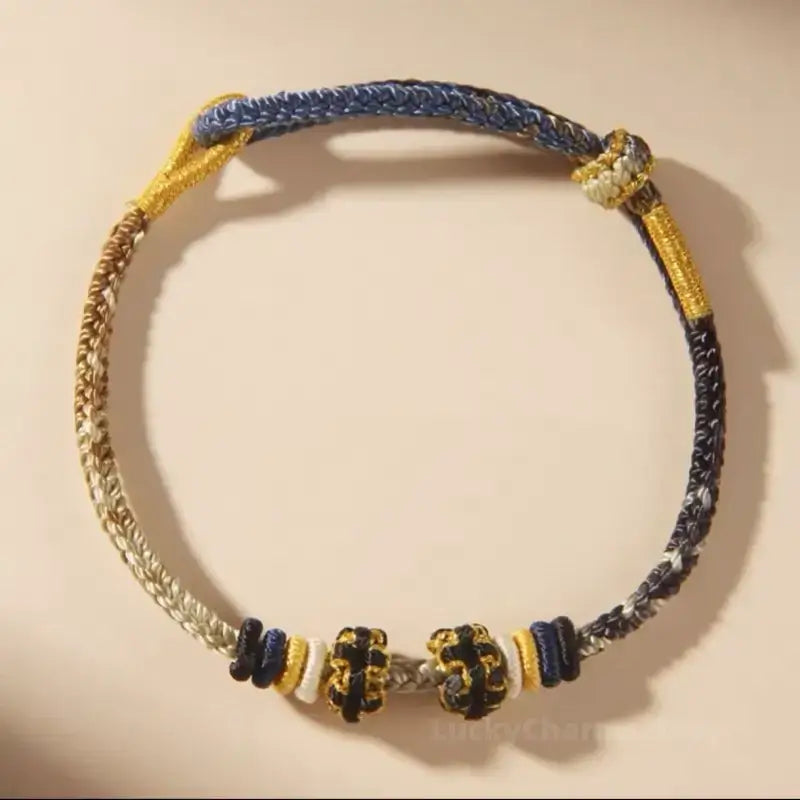 Dark blue and gold gradient braided rope bracelet featuring DIY peach blossom knot accents.
