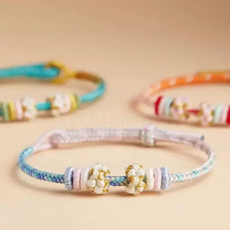 Handwoven Putuo peach blossom knot gradient braided string protection bracelets in pastel shades.