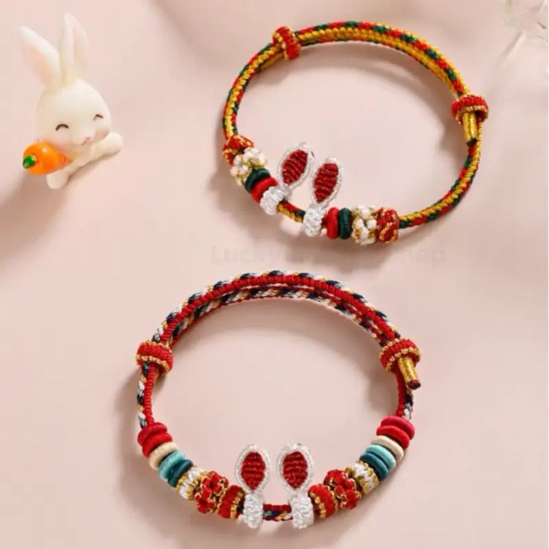 Two handmade braided lucky rabbit ear bracelets in red and green colorways.