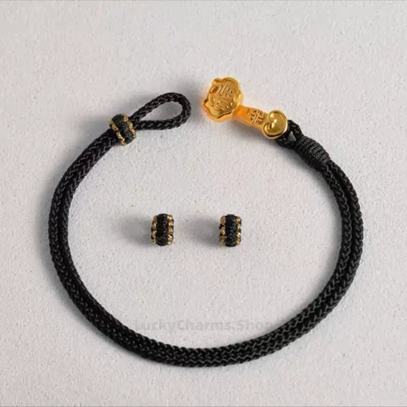 Black braided hand rope bracelet featuring a gold-plated Ruyi clasp and 2 spacer rings.