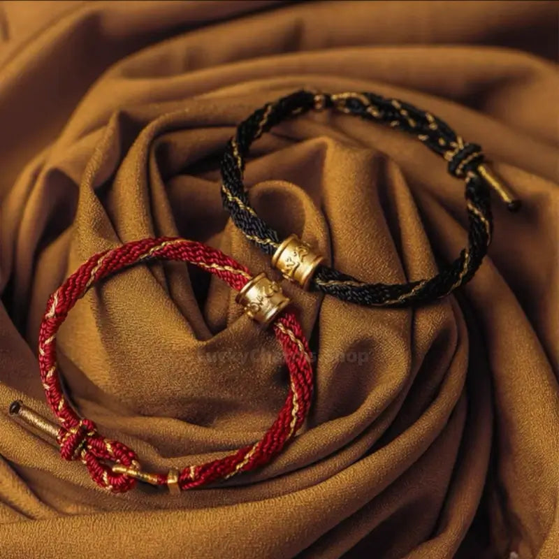 Pair of red and black Tibetan braided couple bracelets with gold Six-Syllable Mantra fortune turning beads on silk.