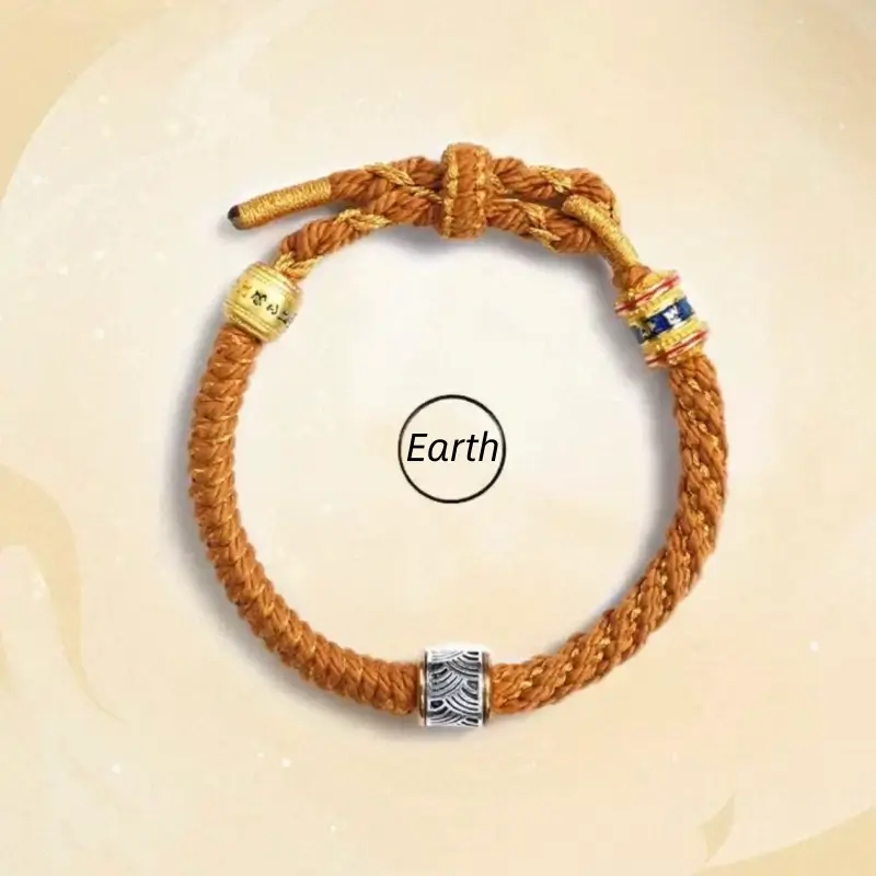 Earth style yellow-brown handwoven Five Elements bracelet with silver wave bead and gold mantra charms.