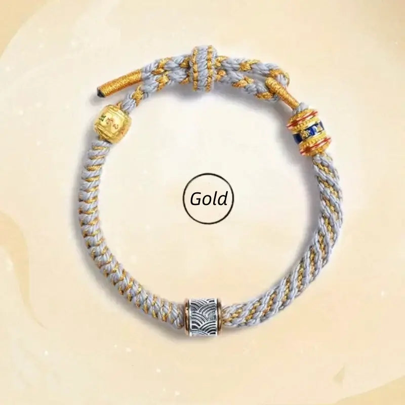 Gold style light gray woven Five Elements lucky bracelet with silver wave charm bead and mantra accents.