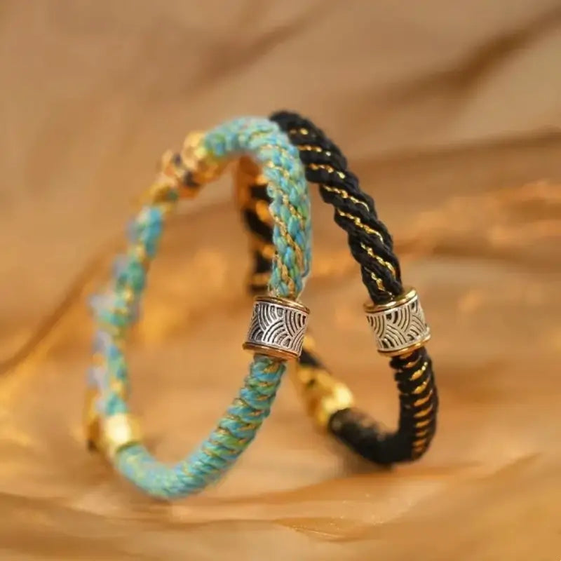 Turquoise and black braided rope lucky cord bracelets featuring silver wave charm beads and gold accents.