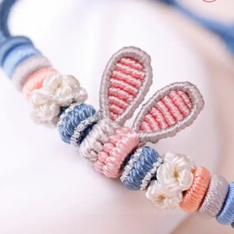 Close-up of handmade braided blue bracelet showing detailed woven Judy rabbit ears charm.